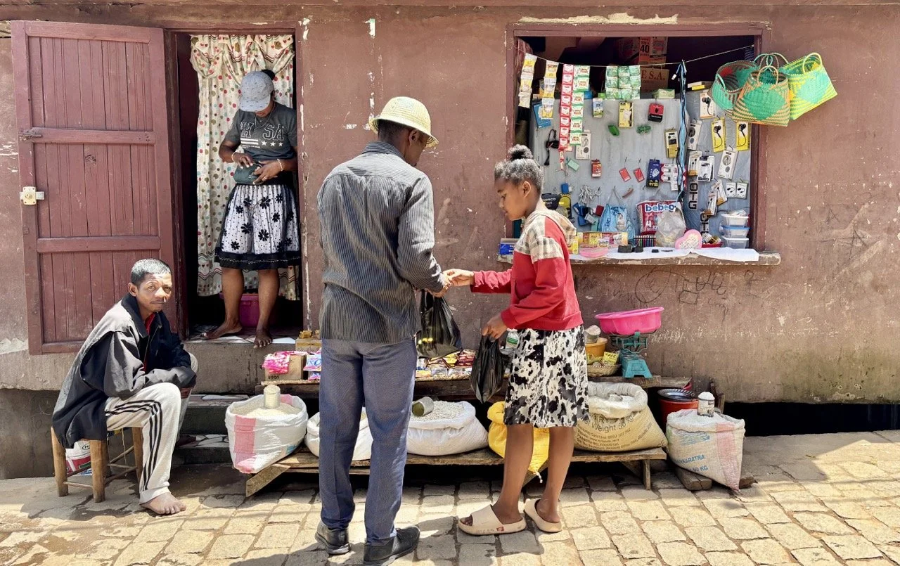Ranomafana 市集攤位與熱帶水果，文化與美食紀實攝影素材；Ranomafana village market stalls with tropical fruit — cultural and food documentary photography.