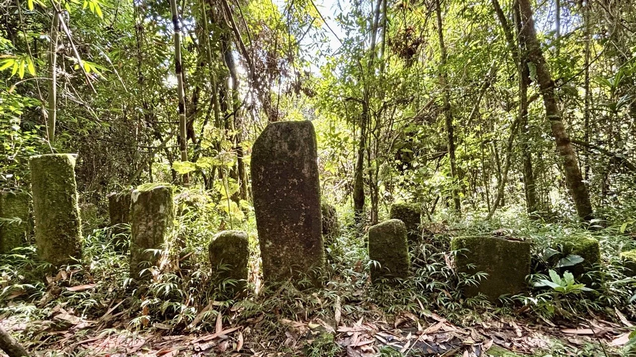 Famadihana 儀式中的包裹過程：長者與家屬小心取出遺骨、淨化與換新布，說明文化緣由與族群傳統；Famadihana rewrapping ritual — elders and family members carefully exhuming, cleansing and rewrapping remains, explaining cultural reasons and clan tradition.