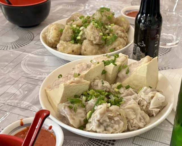 路易港中央市場攤位特寫，當地人在販售熱騰騰 Dholl Puri 與粉紅 Alouda，呈現模里西斯在地美食文化。 Close-up of Port Louis central market stall selling hot Dholl Puri and pink Alouda, showcasing Mauritius local food culture.