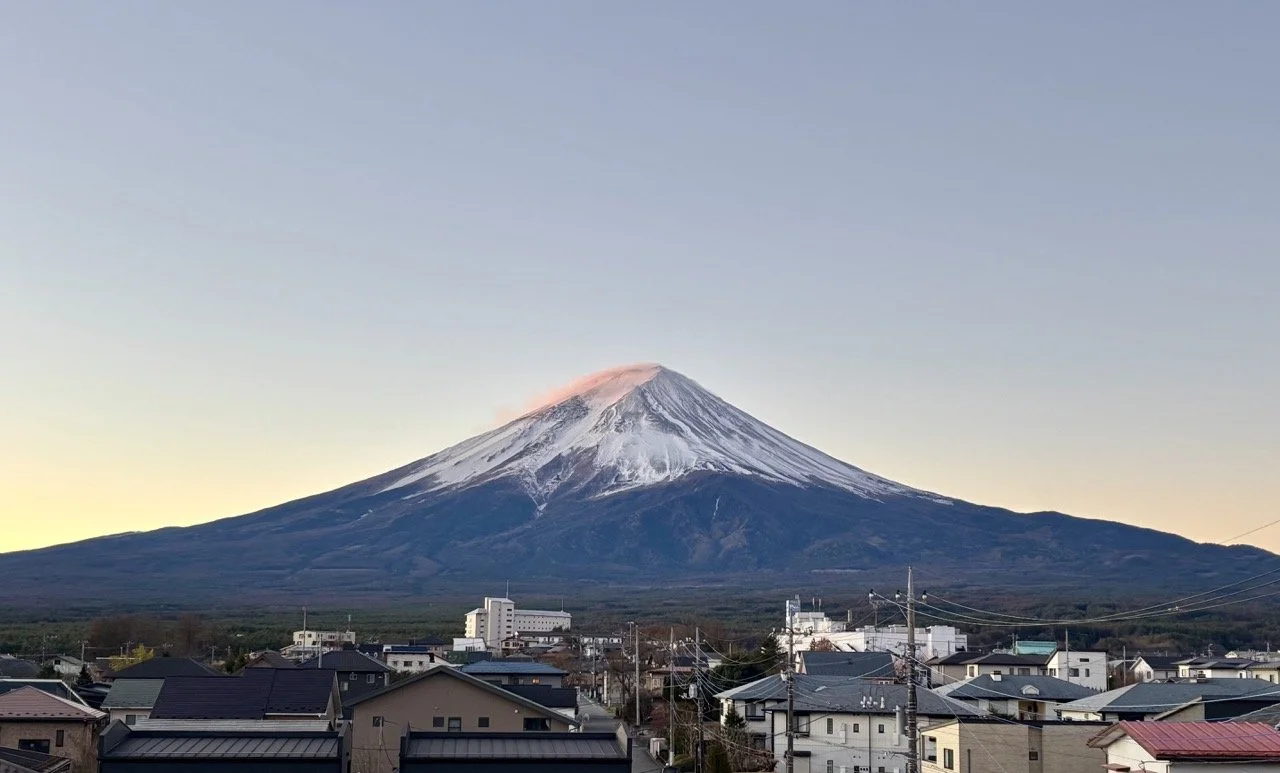 日出時分的河口湖湖面與富士山景色，柔和晨光映照山峰，適合富士山攝影與清晨散步。