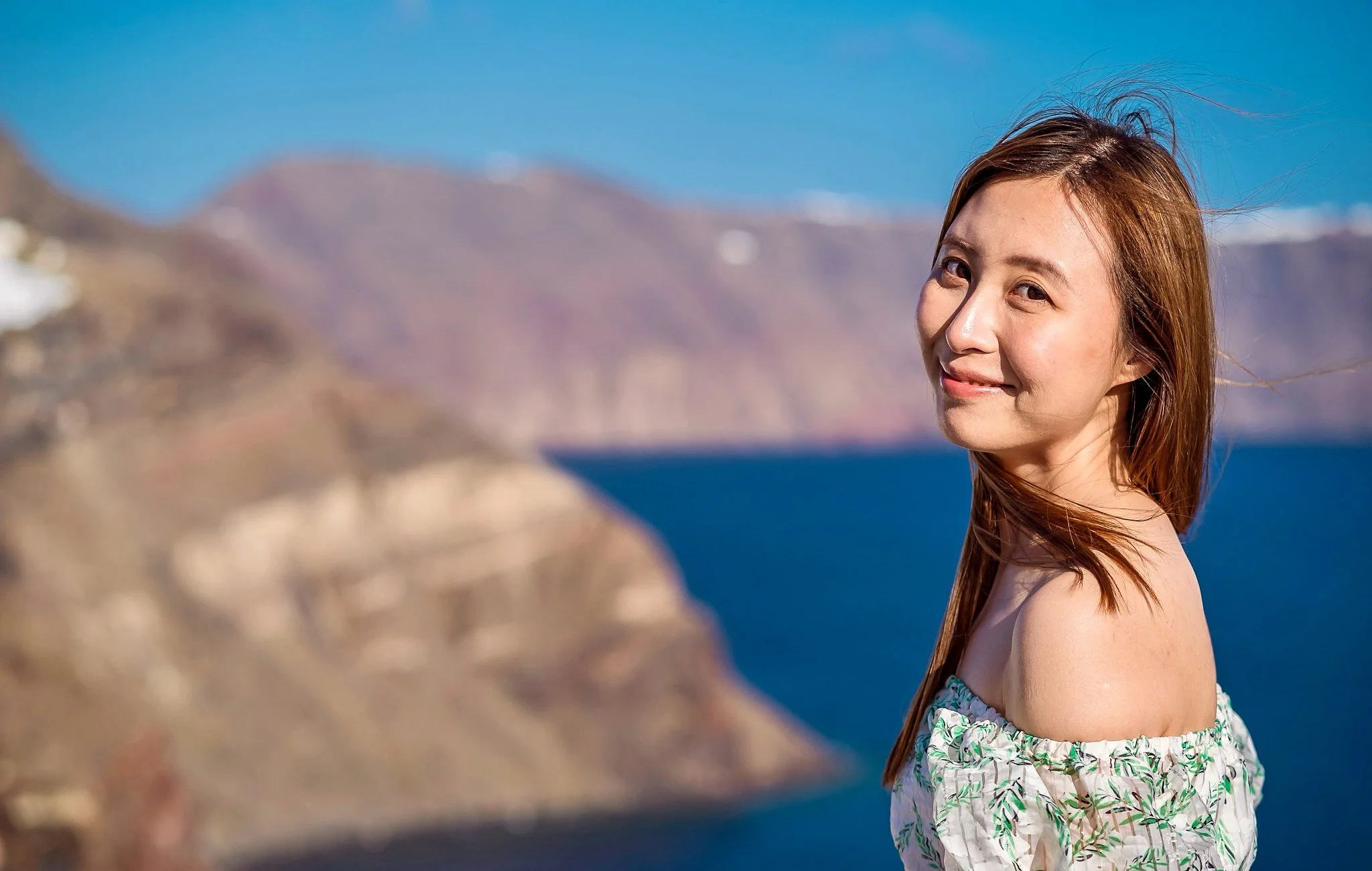 Skaros Rock 火山岩剪影婚紗構圖，壯闊山海背景適合戲劇化婚紗照；Skaros Rock silhouette wedding composition — dramatic volcanic cliff backdrop for epic couple shots.