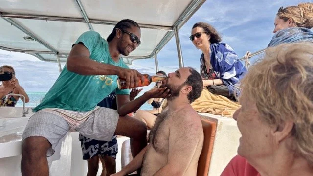 雙體船甲板上的自助午餐場景，海鮮、沙拉與熱帶果盤排列，呈現船上用餐體驗與美味菜色。