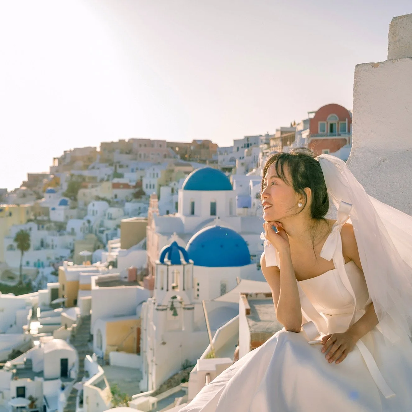 聖托里尼藍頂教堂日出婚紗照：清晨無人光景、柔和金色光線，最佳 Santorini wedding sunrise 拍攝時段；Santorini blue domes sunrise wedding shot — empty morning scene with soft golden light, ideal Santorini wedding sunrise timing.