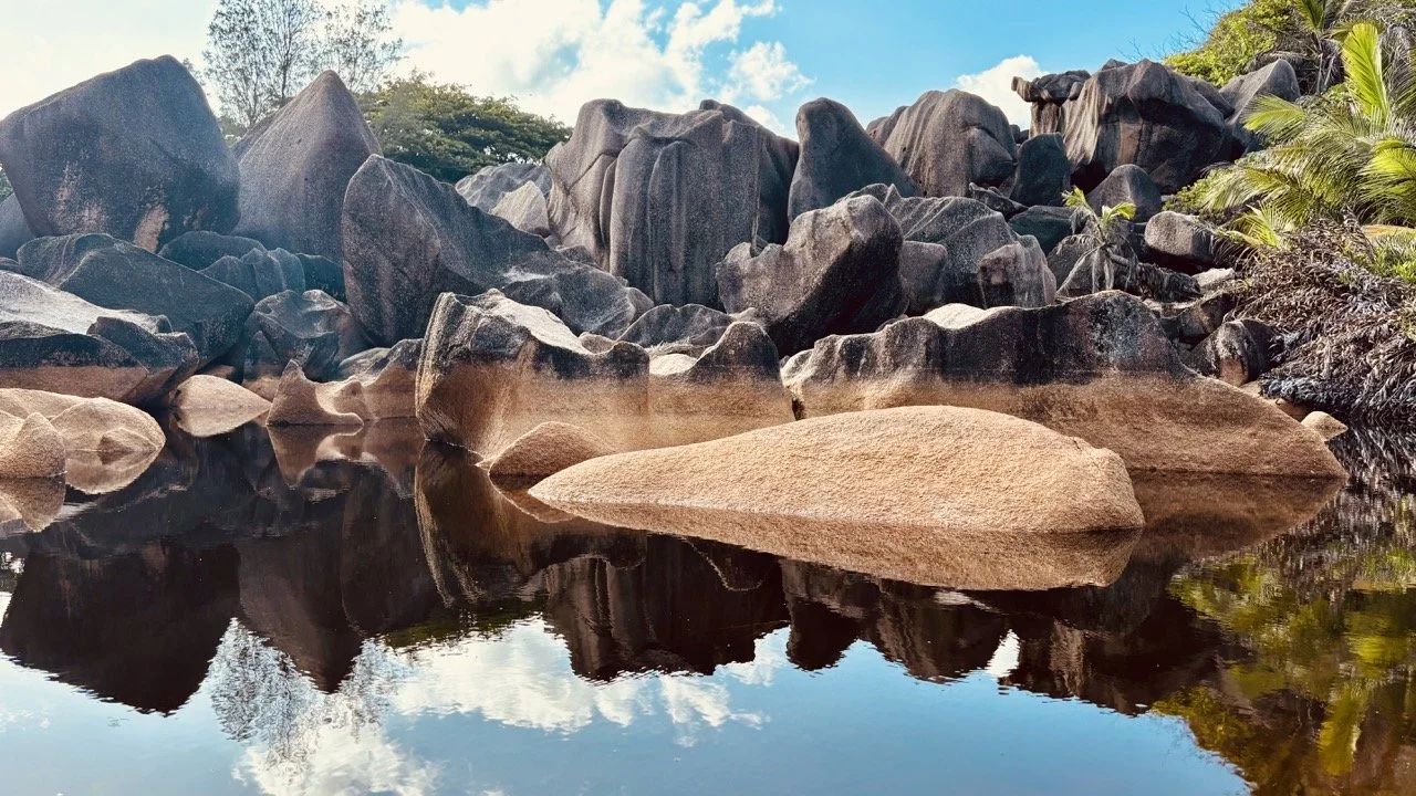 拉迪格島 La Passe 社區街景，周圍可見自行車、熱帶植物與島上住宿及餐飲設施。