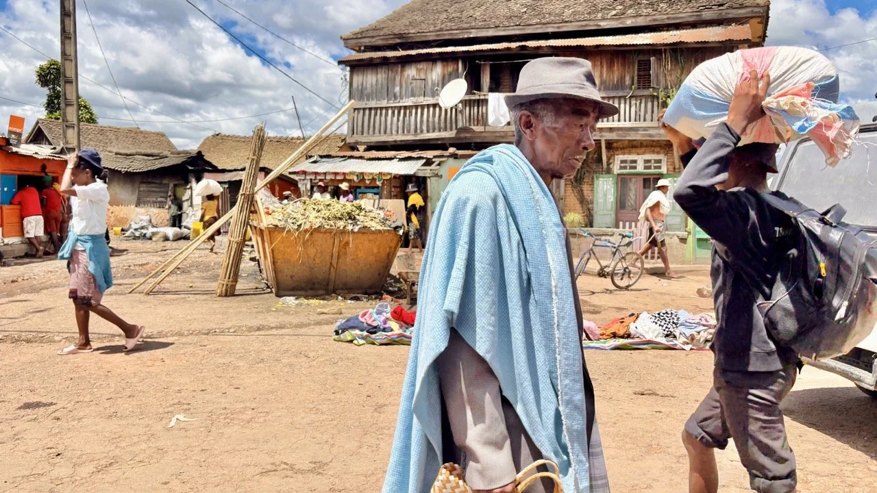 馬達加斯加南方男子傳統服飾：帽子、披布與手杖的服飾細節，說明防曬、地位與成年儀式的象徵；Southern Madagascar male traditional attire — hat, draped cloth and staff details explaining sun protection, status and coming‑of‑age symbolism.