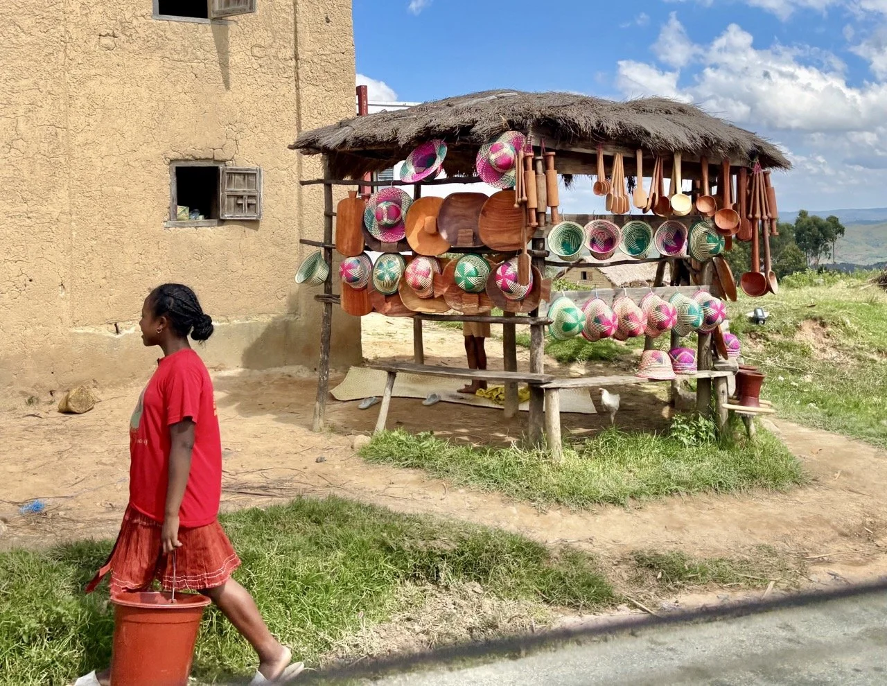 手工藝品攤位展示：編織籃與木雕紀念品，支持當地工匠與文化保存；Handmade crafts stall at Ranomafana market — woven baskets and woodcarvings supporting local artisans and cultural preservation.