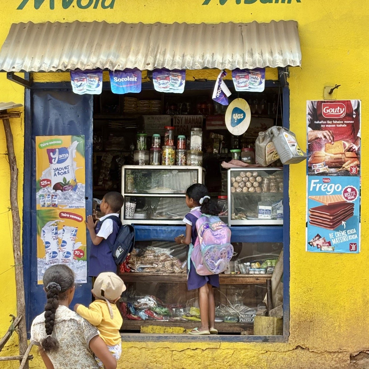 市場交易特寫：手部交換現金與商品的瞬間，捕捉市場經濟與人情互動；Market transaction close‑up at Ranomafana — hands exchanging cash and goods capturing market economy and human interaction.