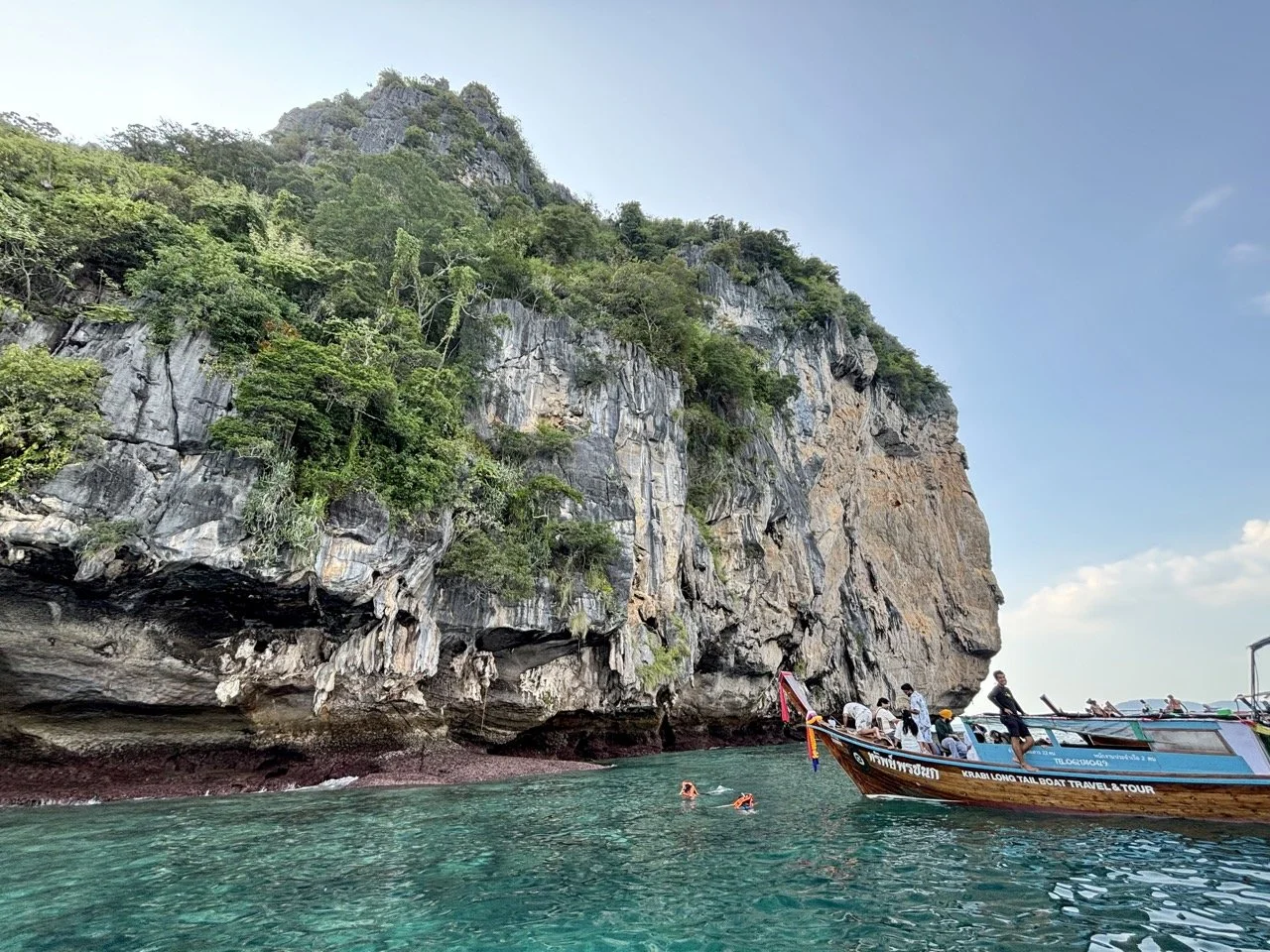 甲米天然溫泉瀑布景觀，溫泉水沿著岩石流入森林水池，呈現 Krabi Thailand 獨特的地熱自然環境。 Natural hot spring waterfall in Krabi, with warm water flowing over rocks into pools surrounded by tropical forest.