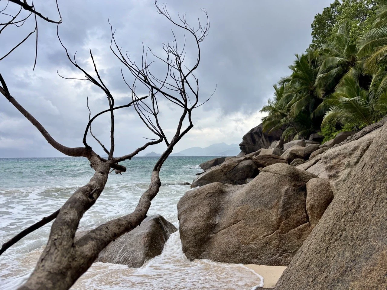Anse Soleil Beach 西向海岸的夕陽景色，金色陽光灑在海面與岩石上，適合拍攝塞席爾浪漫日落。