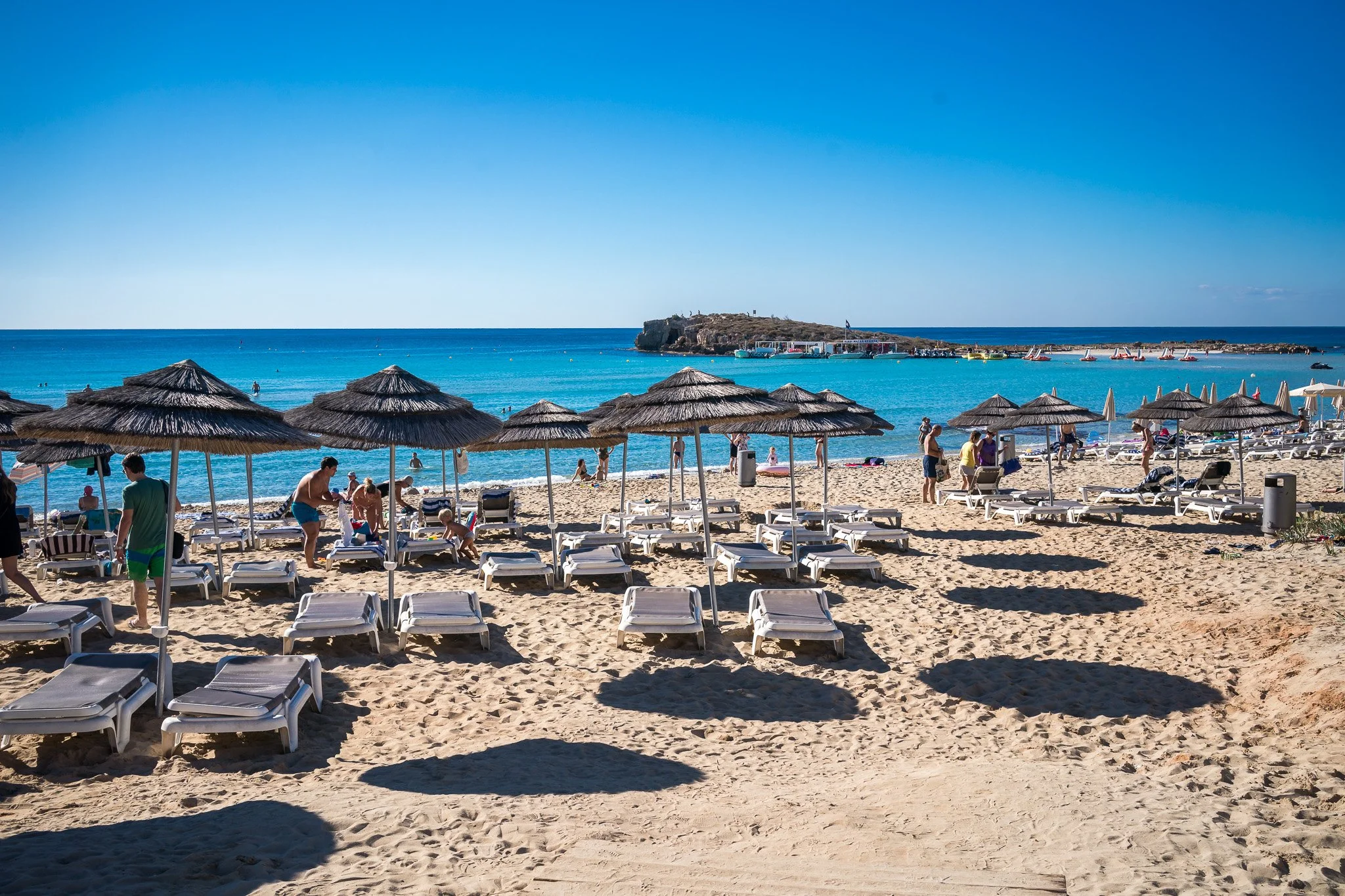 早晨 Nissi Beach 檔販與準備活動的生活紀錄畫面，適合旅遊故事型攝影。