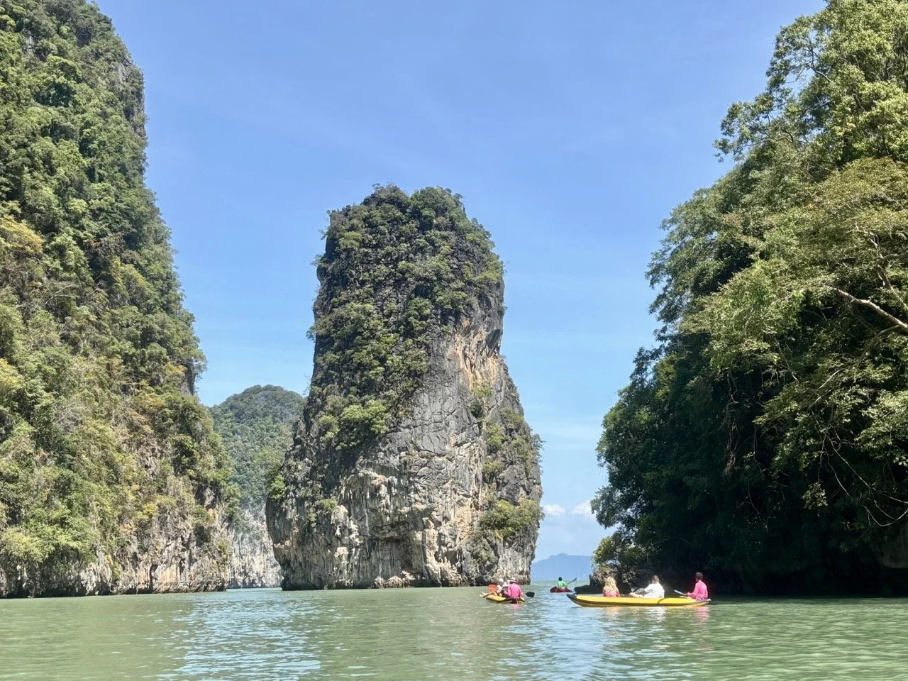 泰國傳統長尾船航行於攀牙灣，前往 James Bond Island 詹姆士龐德島，背景為壯觀的海上石灰岩山壁。