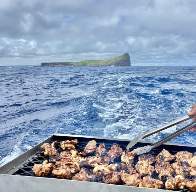 Benitiers 島上海鮮燒烤午餐場景，桌上擺滿當地烤魚與熱帶水果，適合描述 island lunch 與 Mauritius culinary experience。