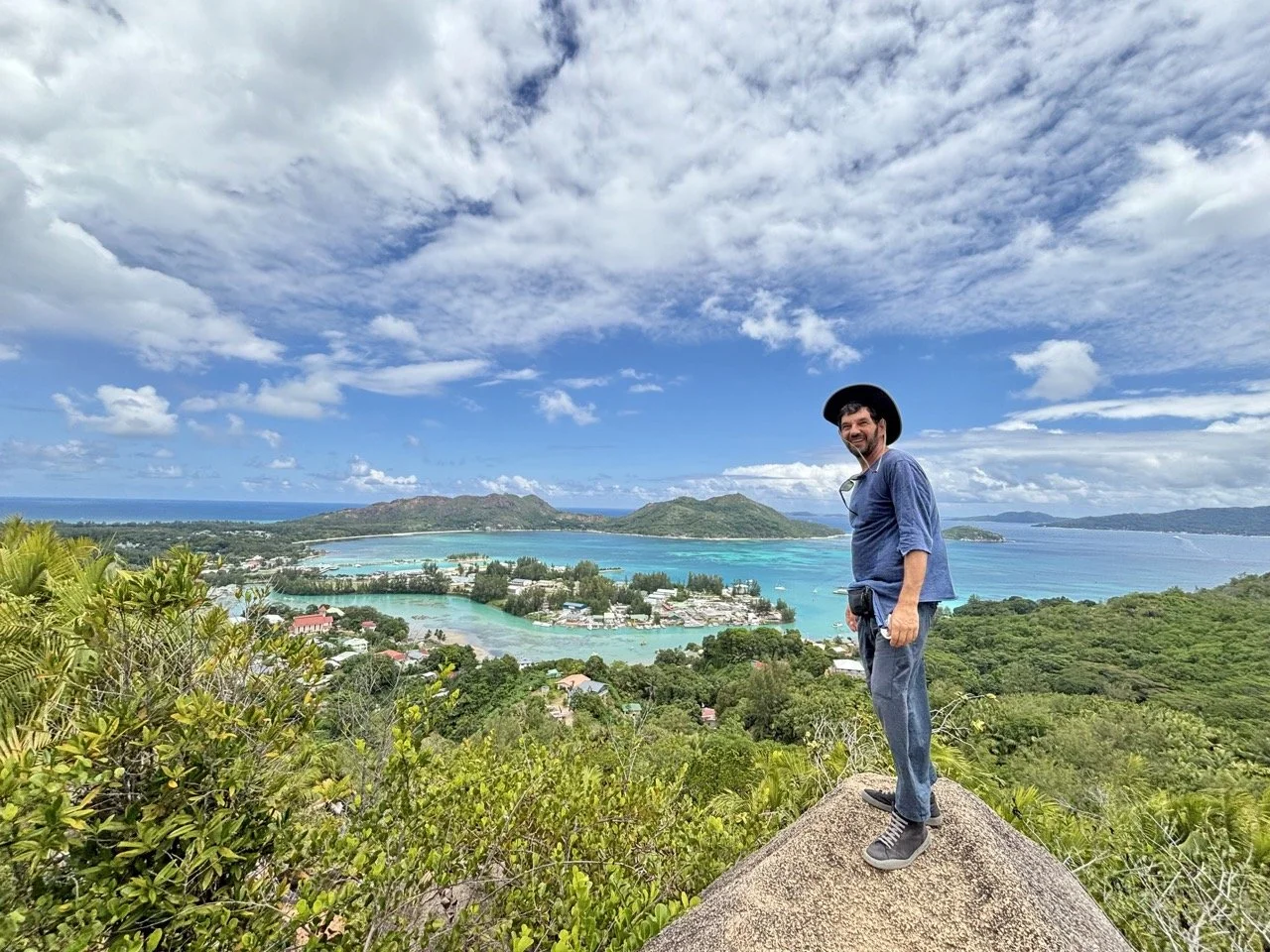 Anse Lazio 海灘全景，熱帶棕櫚樹、花崗岩巨石與印度洋藍色海水展現普拉蘭島最具代表性的海島風光。