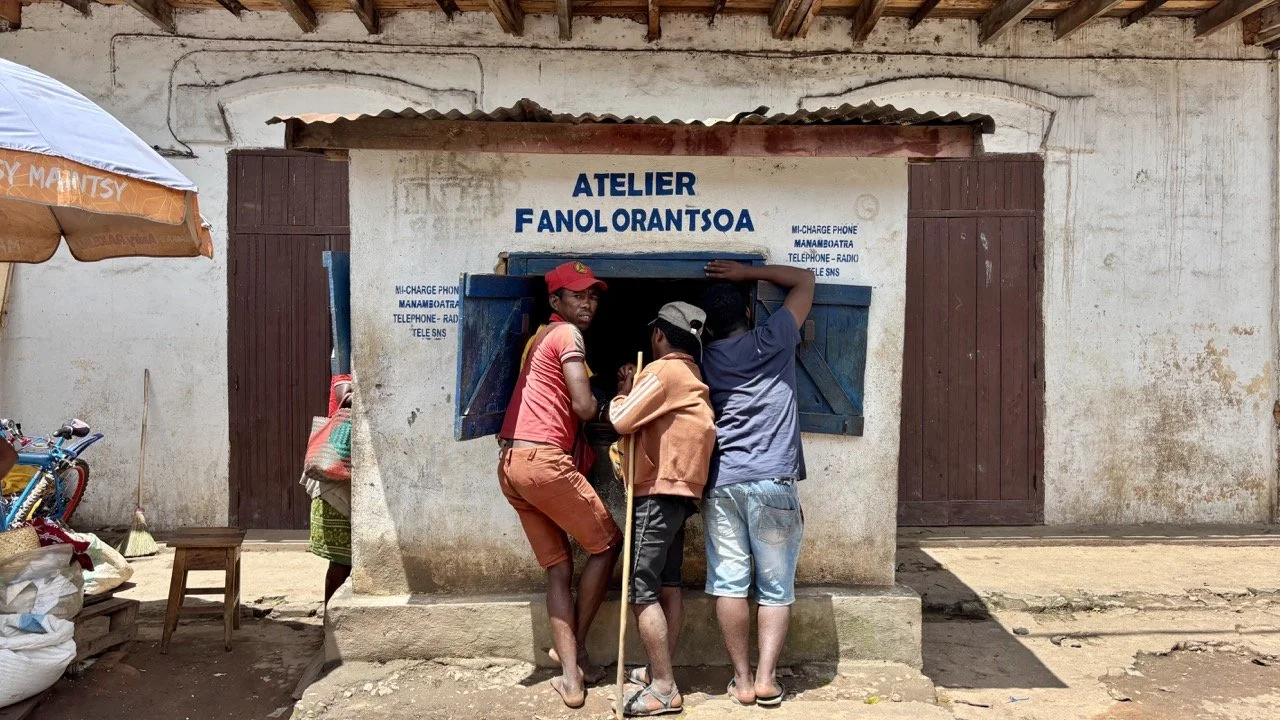 乾貨攤位與散裝穀物：豆類、穀物與香料桶的構圖素材，紀實市場經濟生活；Dry goods bins at Ranomafana market — legumes, grains and spice barrels composing documentary market economy imagery.