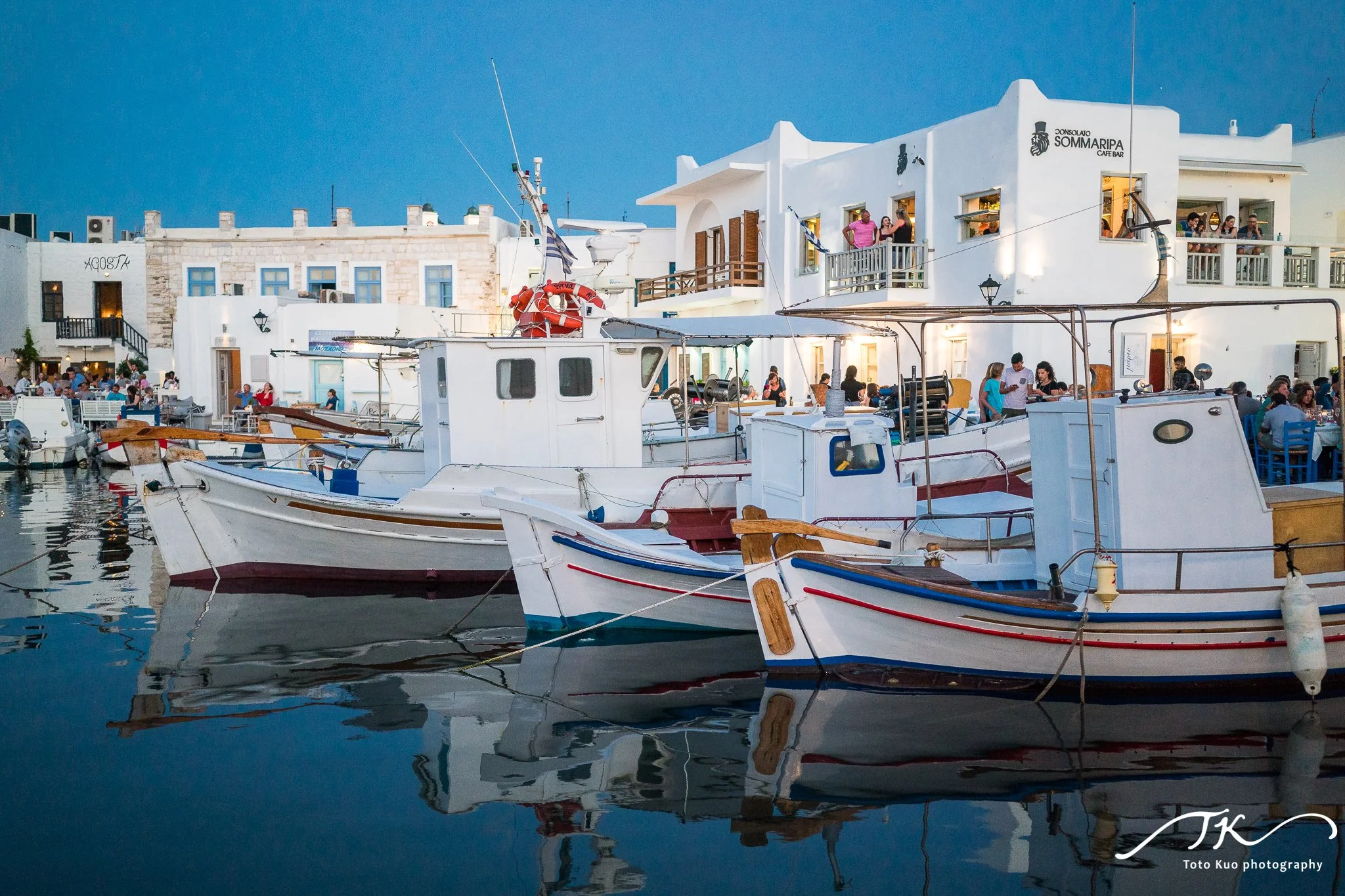 Naoussa harbor sunset on Paros, included in the Paros travel guide with shooting tips for reflections, long exposures and seafood restaurant photos.