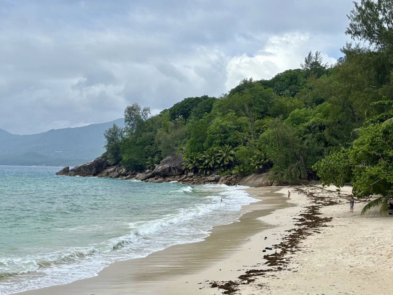 Carana Public Beach 岸邊的深色花崗岩與拍岸海浪，呈現馬埃島北部海岸強烈而富有層次的攝影畫面。