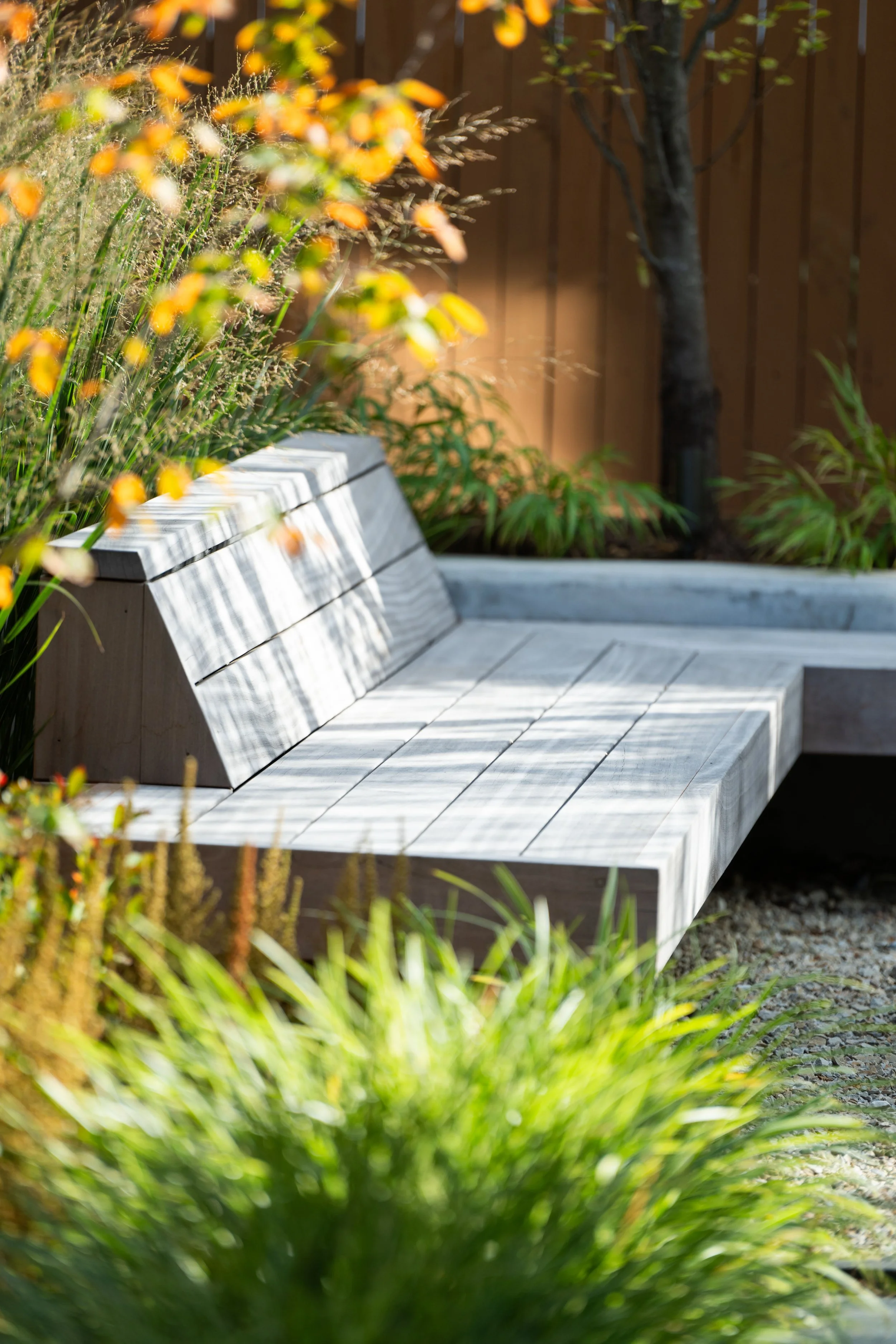 Custom wood bench design by FORM Garden Designs offers a place for relaxation amid the hustle of Alexandria, Virginia.