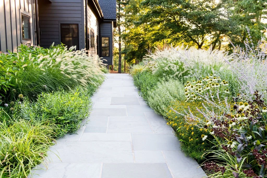 FORM Garden Design designed circulation that includes a blue stone entry, surrounded by soft perennials and grasses that provides year-round texture and habitat for pollinators.
