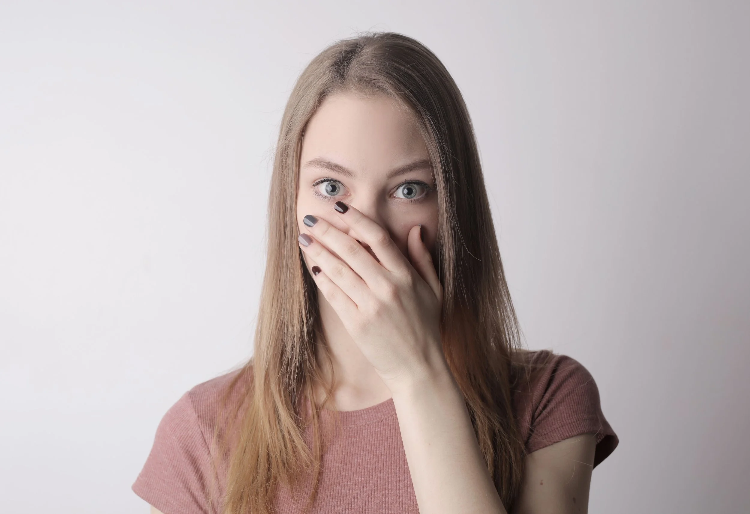 woman smelling her bad breath from tooth decay