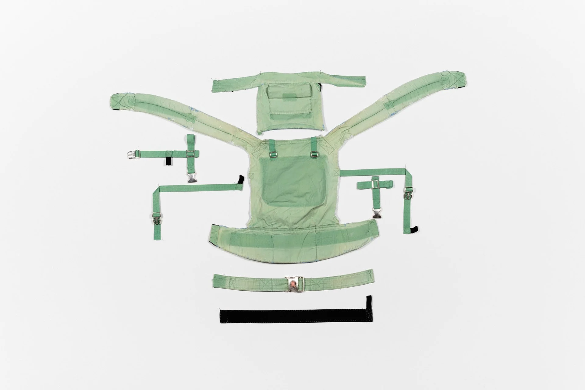 Relic, Fiber: Disassembled baby carrier, mended in silk with sterling silver buckles, human milk tooth, 39” h x 51” w, 2024