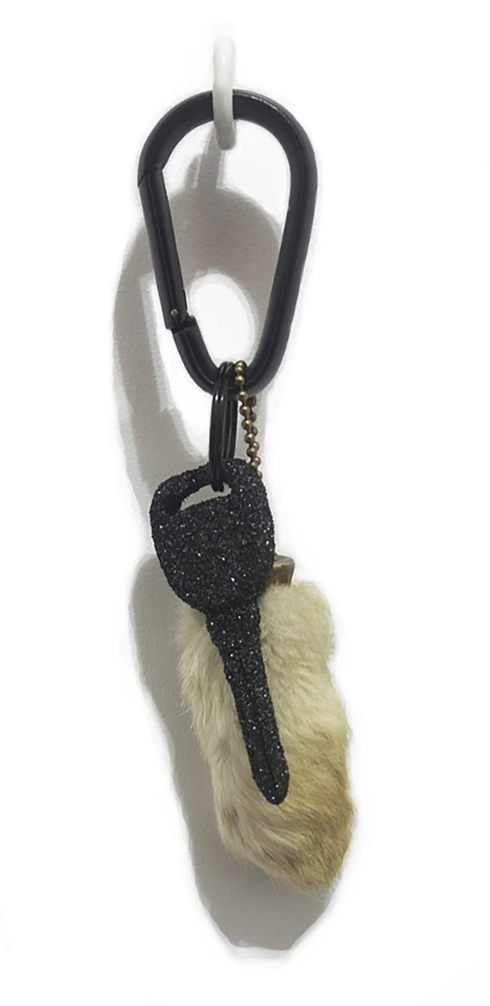Fumbling at the Wheel. found rabbit foot charm circa 1980, black carabiner, incinerated VHS cassettes: Halloween 2 (1981), Friday the 13th: Part 2 (1981), Alone in the Dark (1982), Hell Night (1982), Leprechaun (1993), Scream (1996), Urban Legend (19