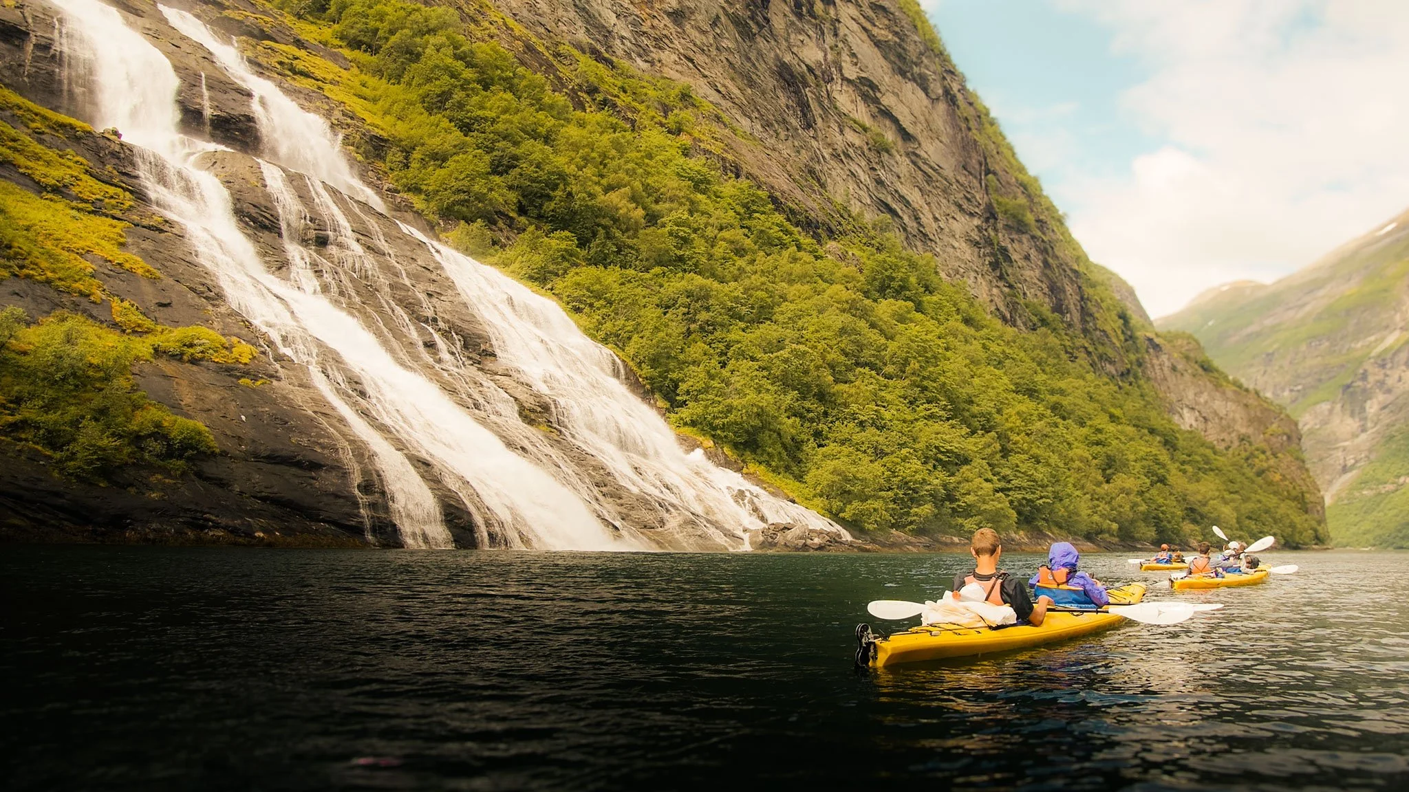  Kayaking through Geirangerfjord as streams tumble down cliffs beside you. 