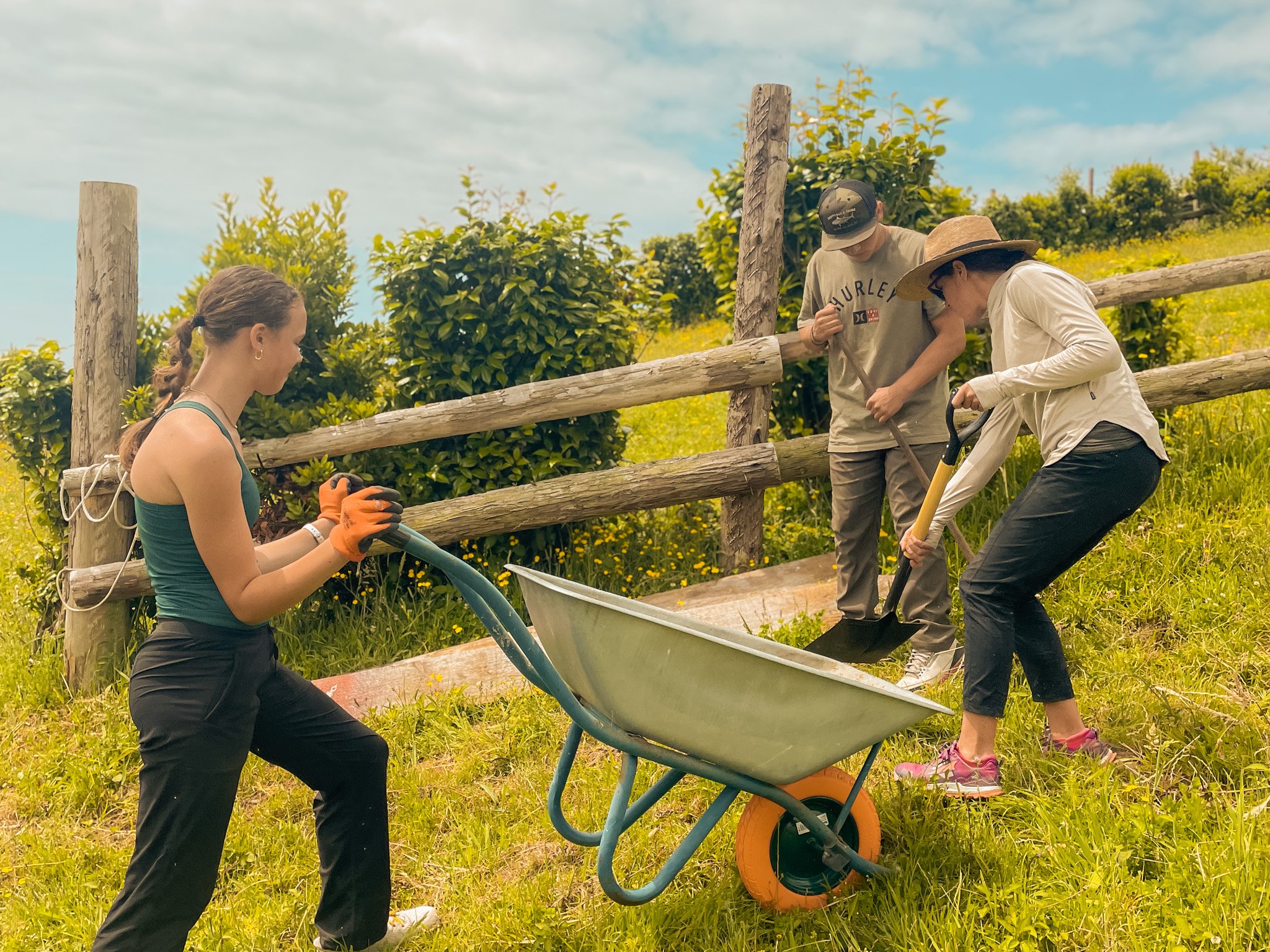 Travelers working together to move a wheelbarrow on a service project