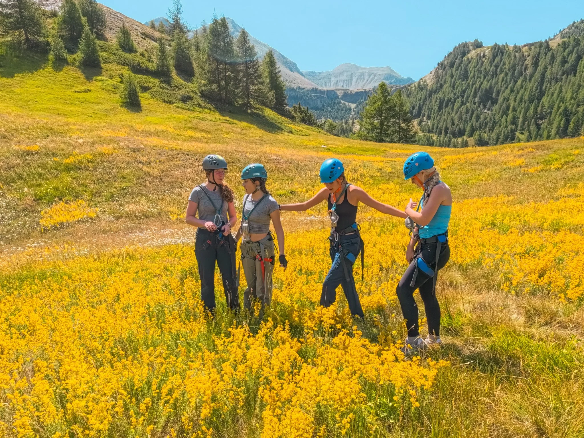 Travelers geared up in helmets and harnesses ahead of a climbing route