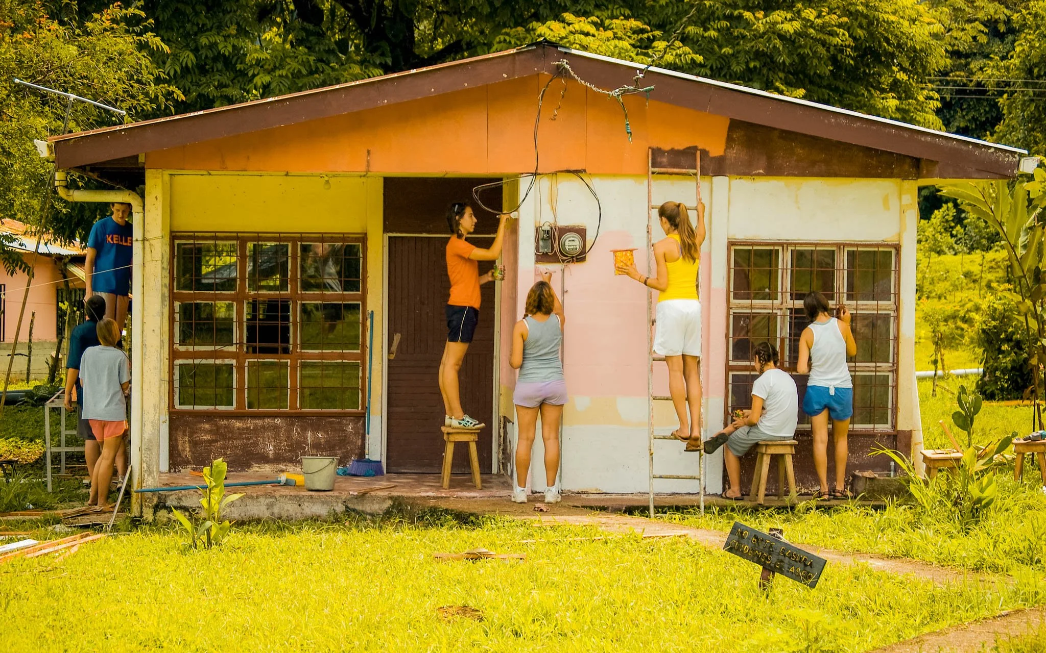 A group of RLT teens repainting the exterior of a community home during a service project in Costa Rica.