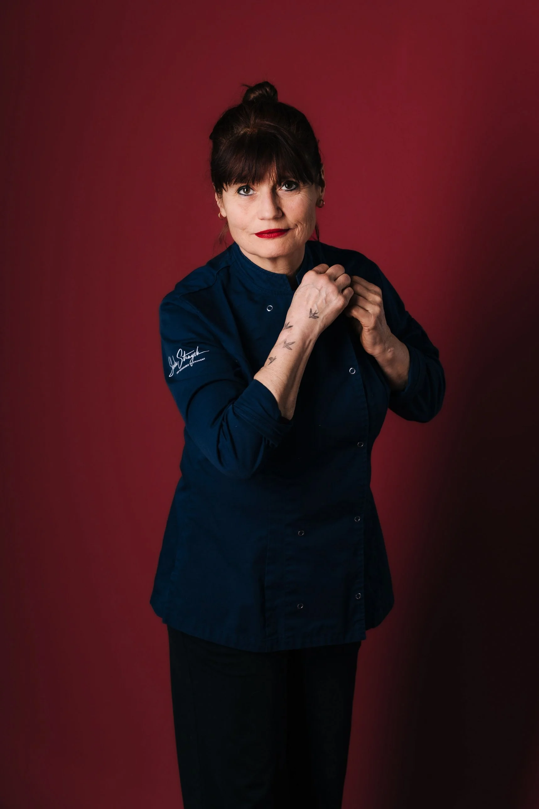 Portret van chef Sheila Struyck in koksbuis voor een rode achtergrond