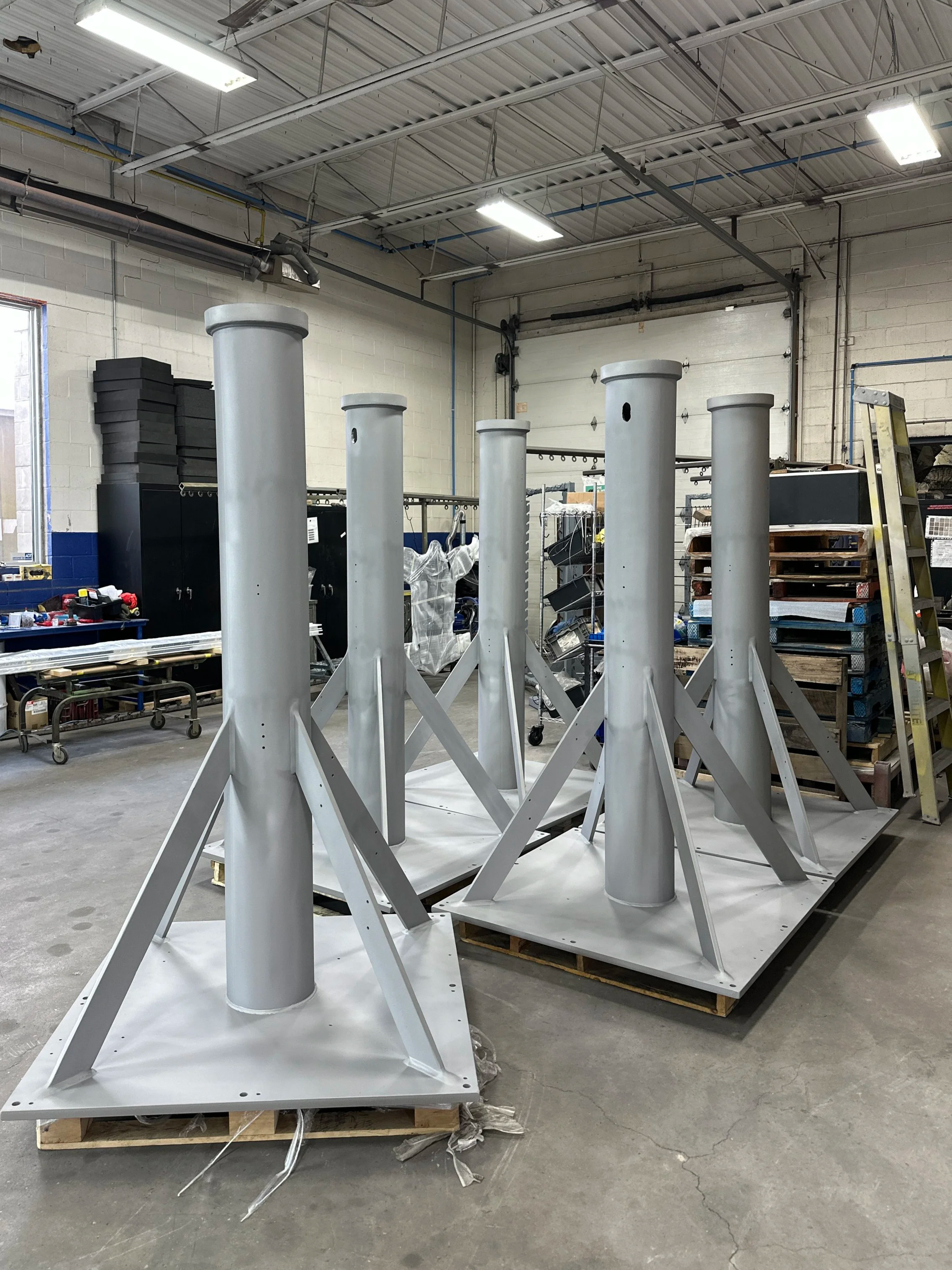 Large steel columns, abrasive blasted to prepare for coating