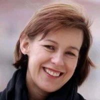 A woman with short brown hair smiling at the camera.