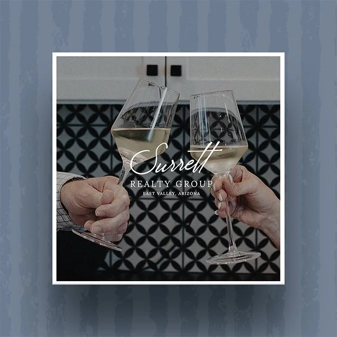 A square graphic of two wine glasses with the Surrett Realty Group logo on top.
