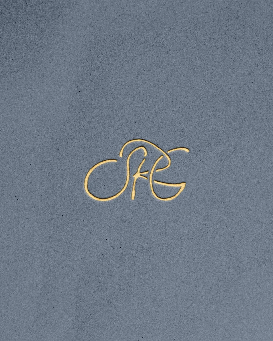 A gold embossed logo spelling the letters "SRG" on a paper background.