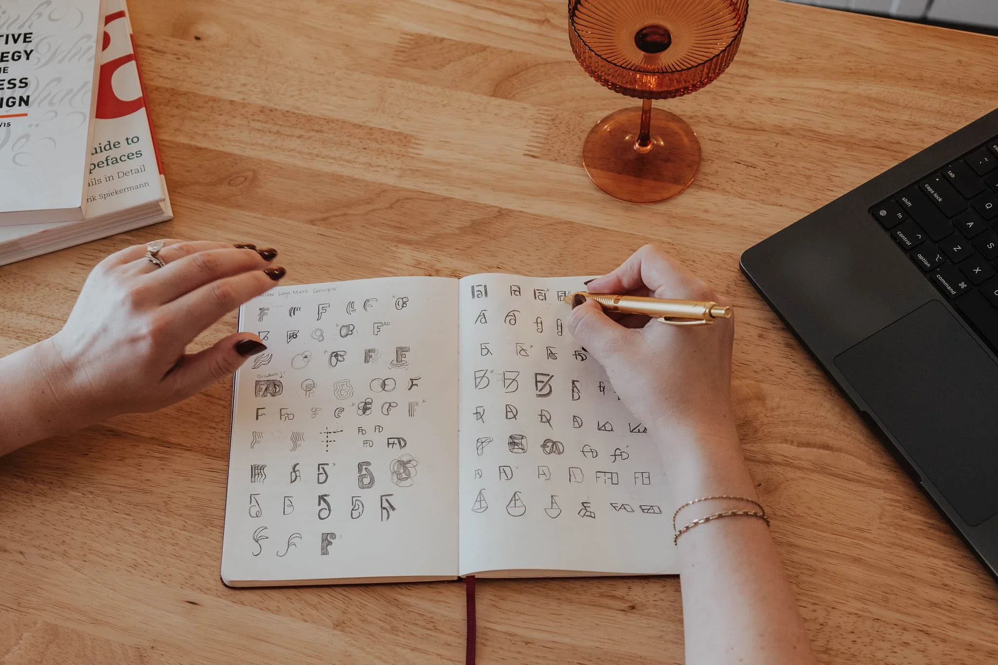 Aliya Mooney drafting logo concepts in her sketchbook, an essential point in the Crafting phase of a brand project.