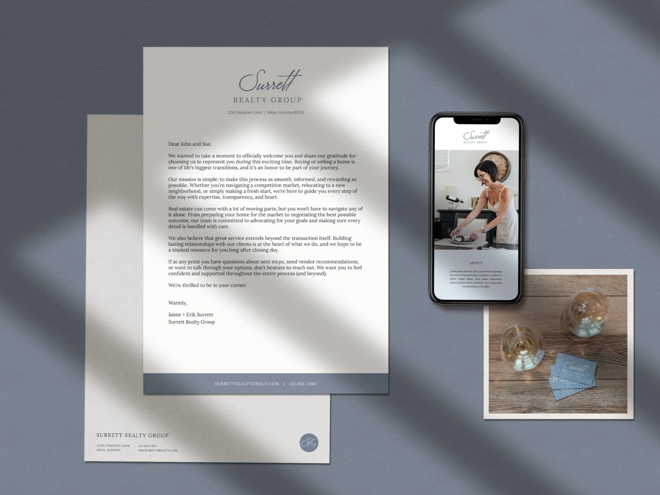 A flat lay of branded materials, including letterhead, a website, and an image of business cards on the floor.