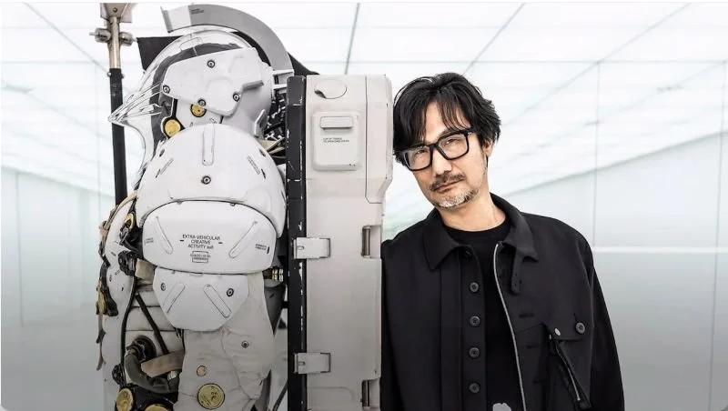 Image depicts Hideo Kojima next to the statue in his studio