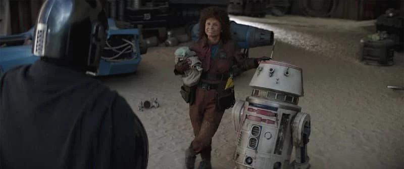 Peli Motto and R5-D4 in front of Din Djarin