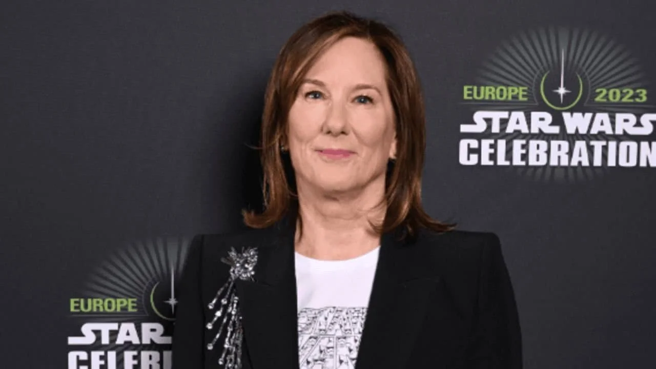 Kathleen Kennedy at Star Wars Celebration Europe 2023, red carpet headshot with the event logo and a dark backdrop behind her