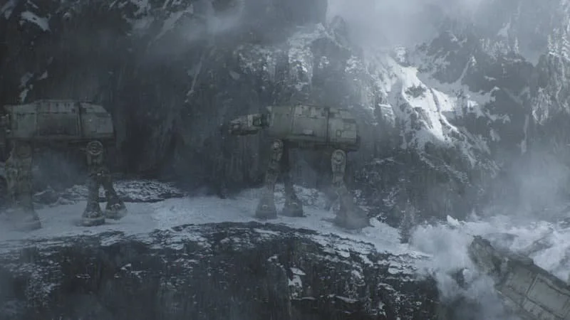 Older models of AT-AT walk a dangerous path through rocky and snowy terrain on an unknown world