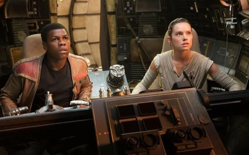 John Boyega as Finn and Daisy Ridley as Rey in the cockpit of The Millennium Falcon.