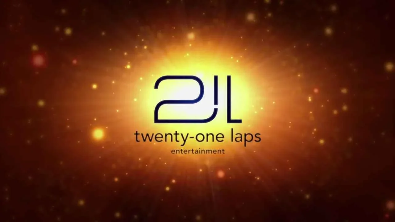 Alternate version of 21 Laps Entertainment logo, a variety of orange and yellow splotches with a bright yellowish center featuring 21L in large letters, the name of the company in smaller letters under that.