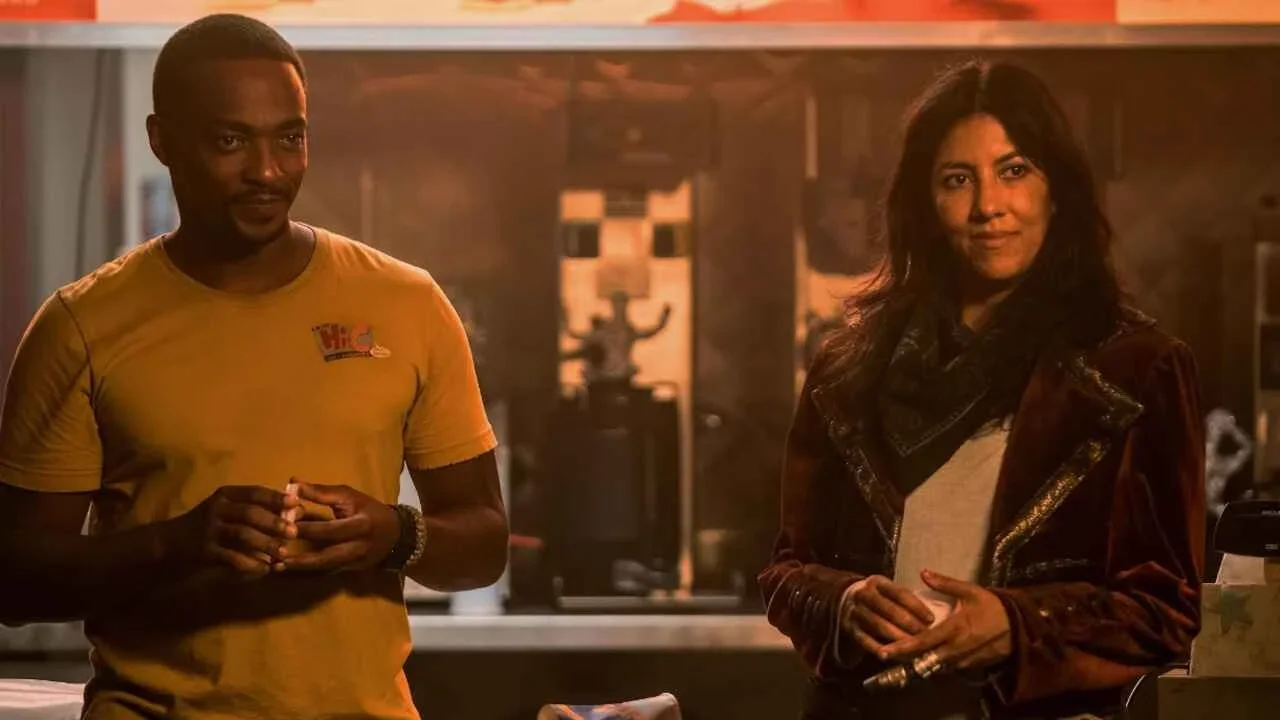 Anthony Mackie and Stephanie Beatriz as John Doe and Quiet respectively, standing next to each other and smirking at something off camera.  Image Source:IMDb