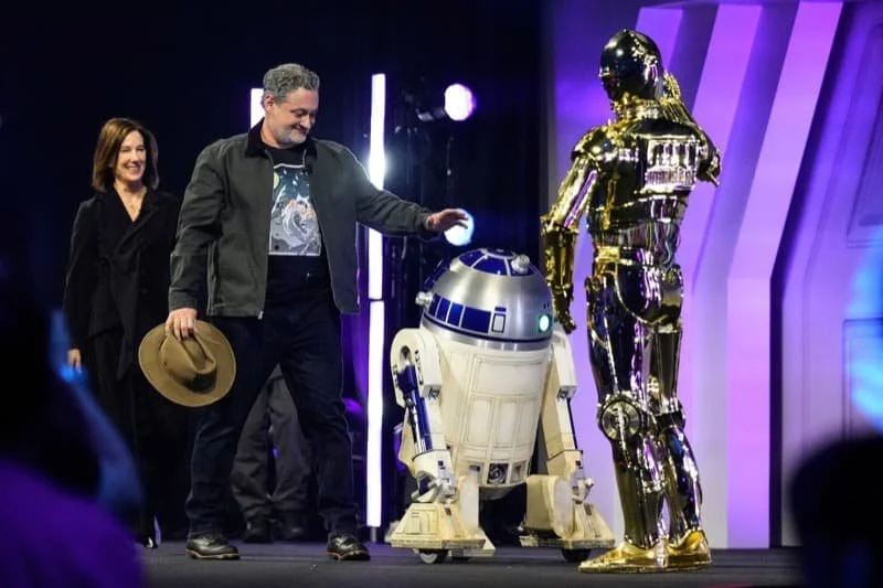 Dave Filoni and Kathleen Kennedy with C-3PO and R2-D2 at Star Wars Celebration Tokyo in 2025.