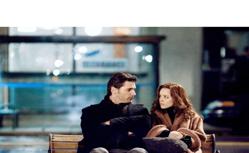 Image Description: Eric Bana and Rachel McAdams looking at each other on a bench