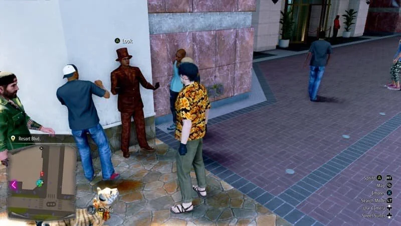 Image Description: Majima standing in front of the bronze “statue” with people surrounding him