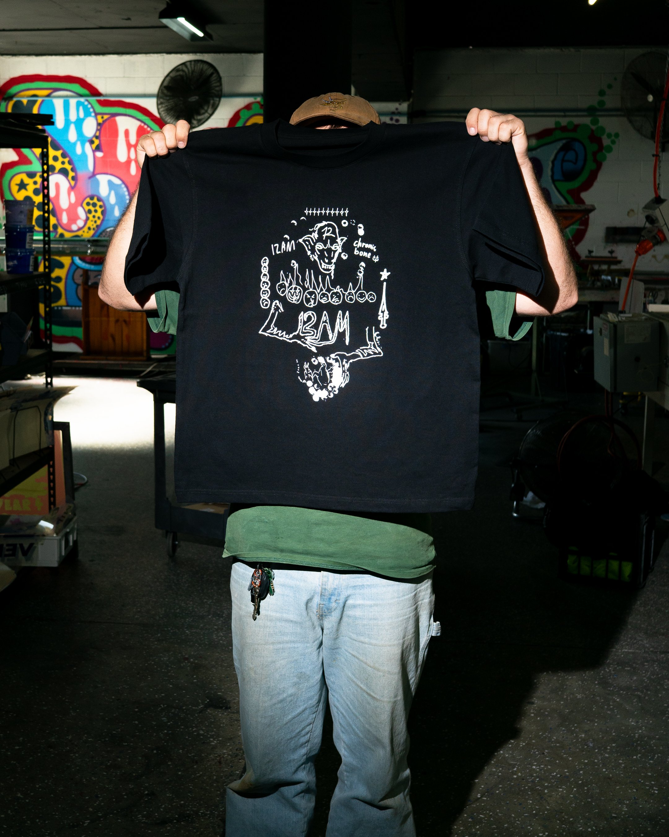 Screen printer holding up custom skateboard brand shirt