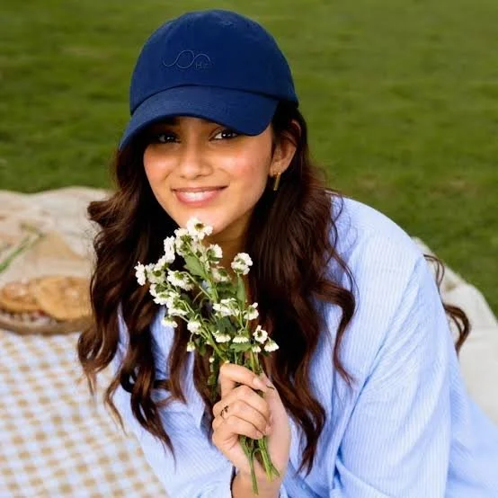 Beautiful woman wearing her navy blue Zero Hertz Cap from Healy World to protect her from EMF as she picnics n the park.