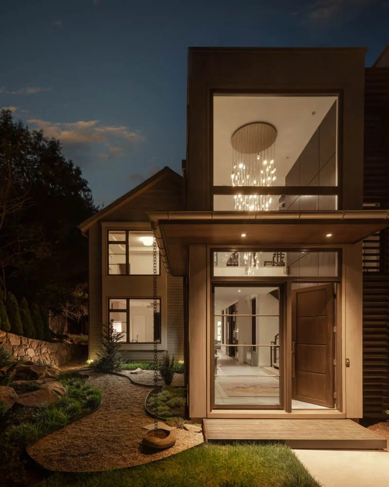 dusk view of modern two story glassed-in entry