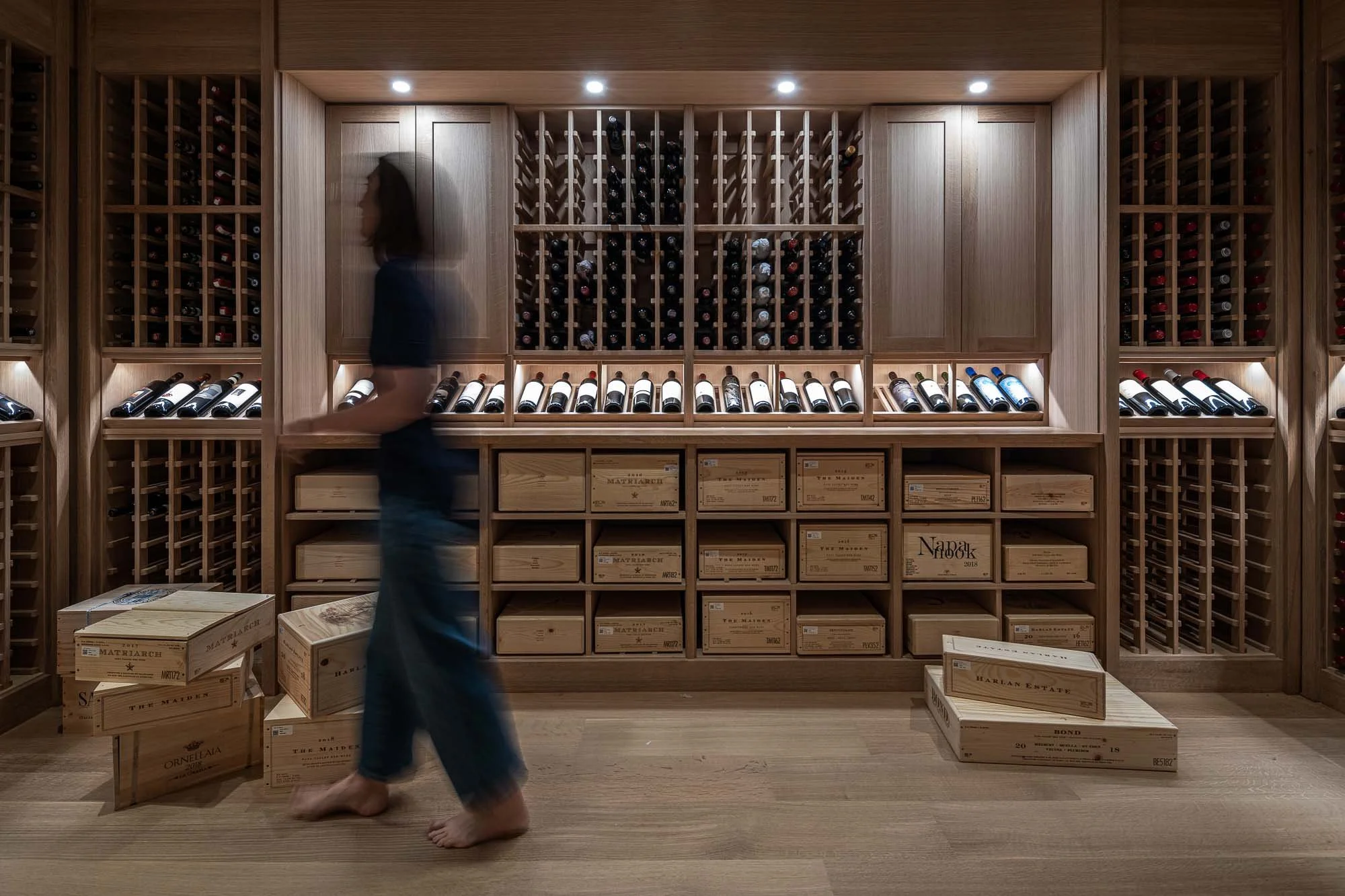 woman walking through wine cellar